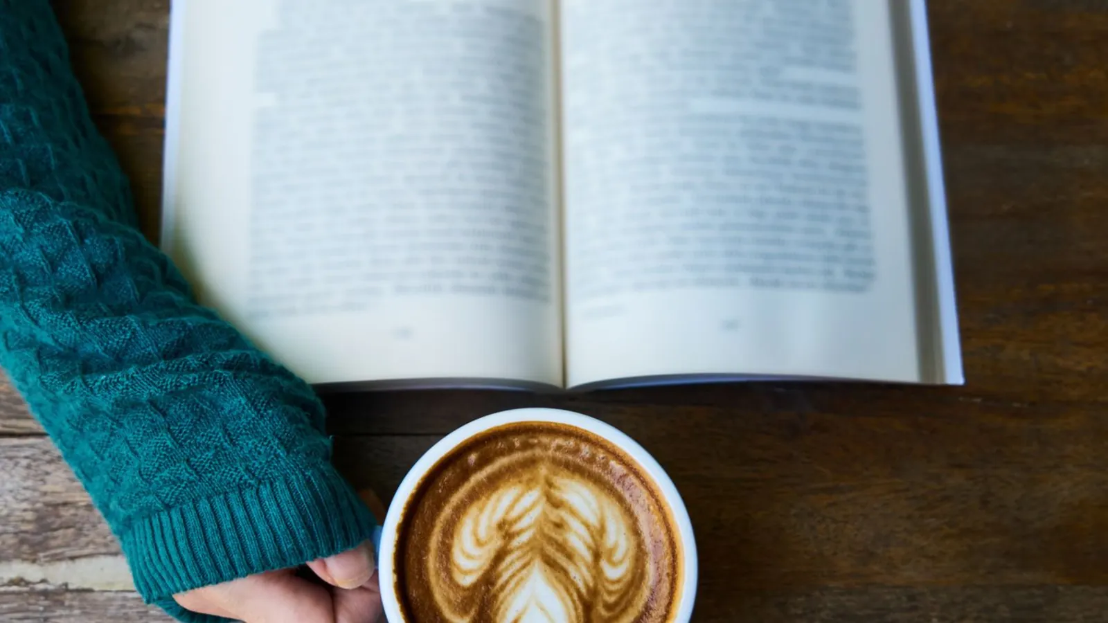 An open book beside a latte
