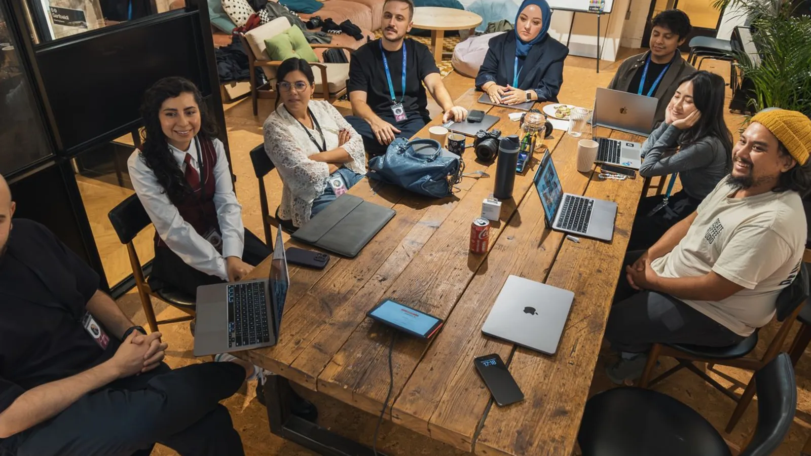 A long shared table of people working on laptops