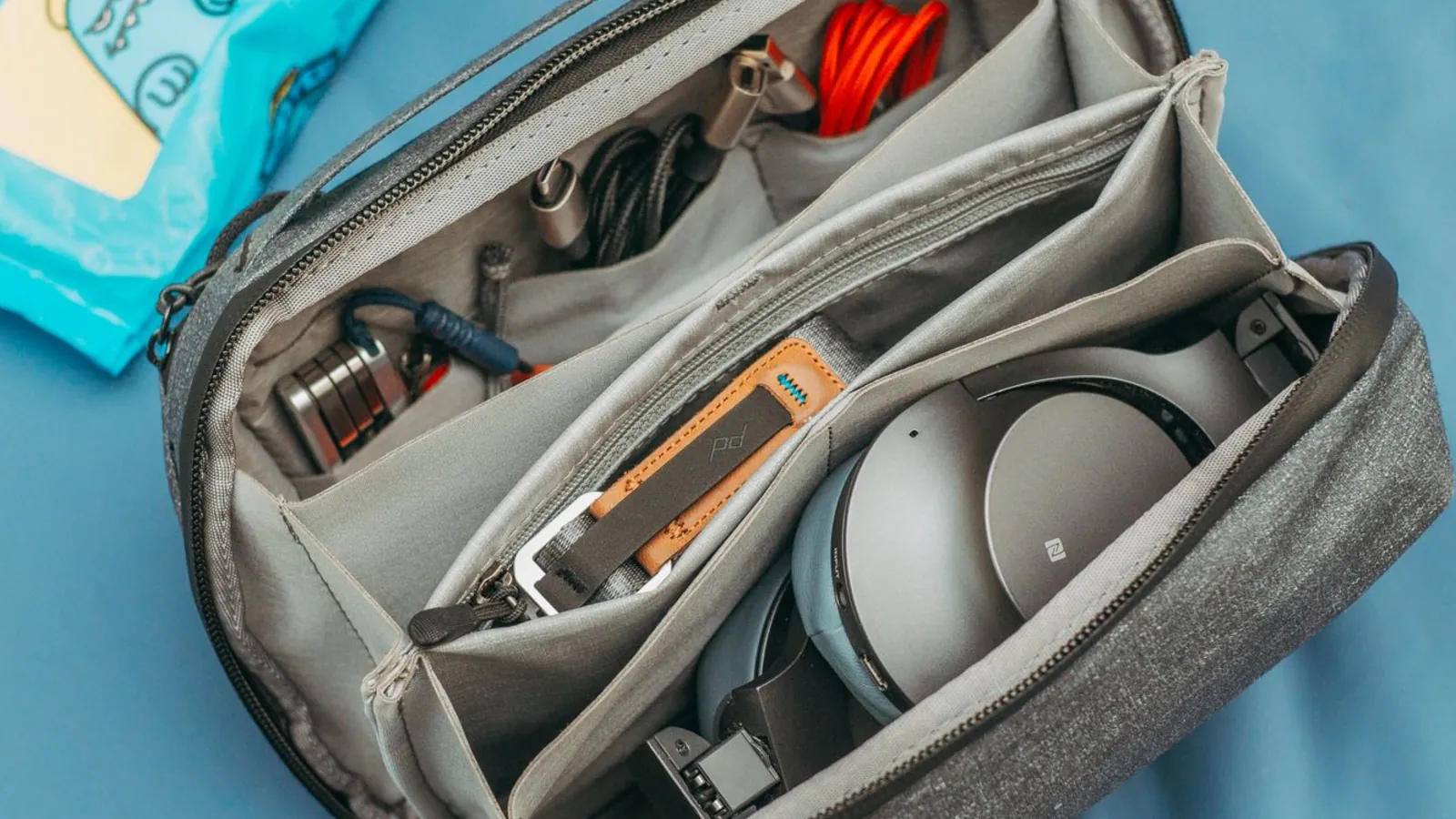 A travel pouch packed with cables and headphones