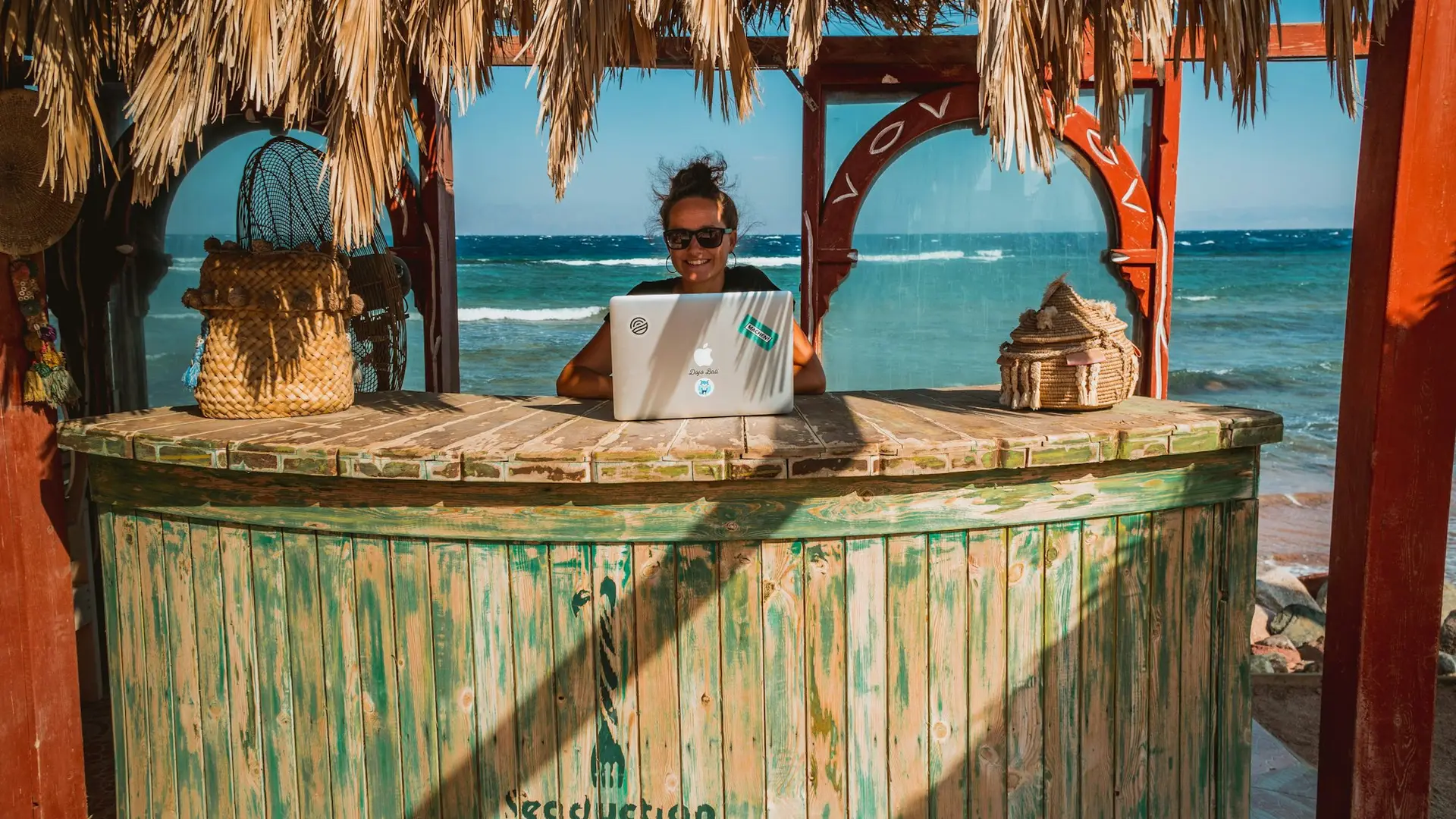 Remote worker on a laptop at a beach bar